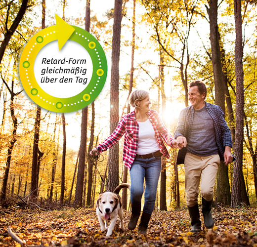 Frau und Mann mit Hund im Wald